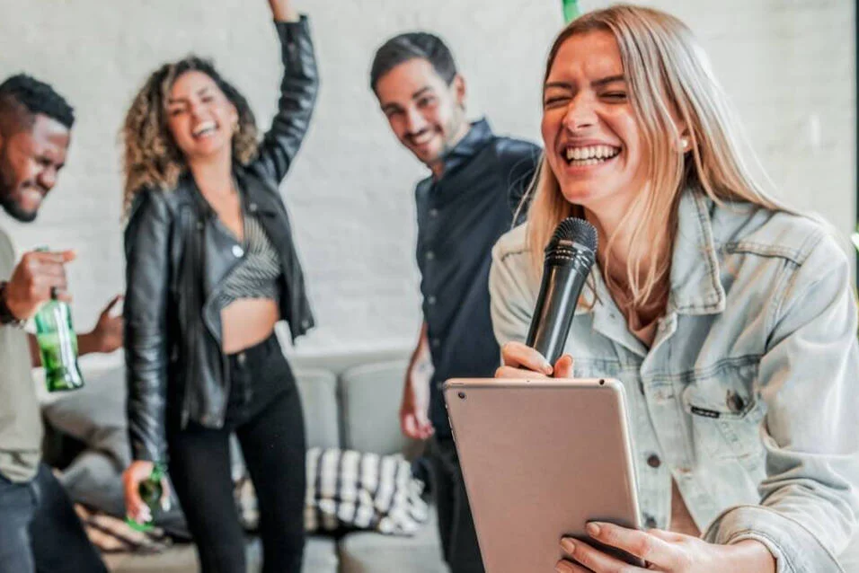 Guest singing karaoke with a microphone and tablet