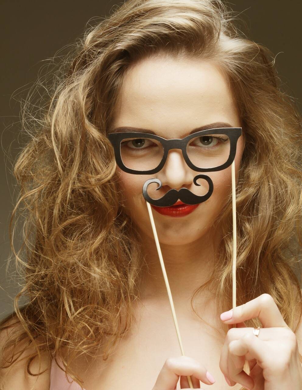 Guest holding photo booth glasses and a mustache prop